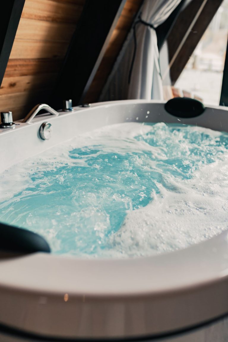 Steaming hot tub with clear bubbling water inside a wooden cabin